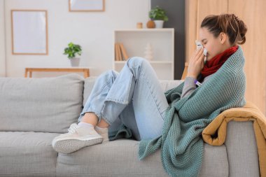 Evde termometresi ve dokusu olan hasta genç bir kadın var.