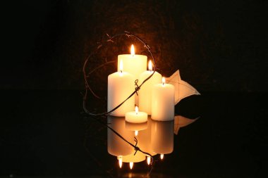 Karanlık arka planda dikenli telli mumlar ve Yahudi rozeti yakmak. Anma Günü