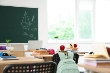 Sınıfta masa başında kitap ve kalem kutusu olan elma, yakın plan.