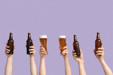 Şişeli eller ve leylak arkaplanda bira bardakları