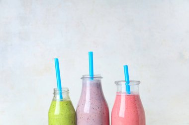 Beyaz arka planda farklı taze smoothie şişeleri