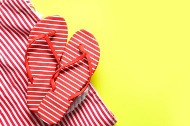 Sarı arka planda şık parmak arası terlikler ve çizgili çanta