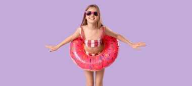 Mayo giymiş şirin bir kız ve eflatun kaplamalı şişme bir yüzük.