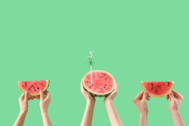 Olgun karpuz parçaları ve kırmızı arka planda saman olan kadın elleri.