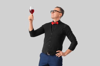 Olgun şarap garsonu. Arka planda kırmızı şarap kadehi.
