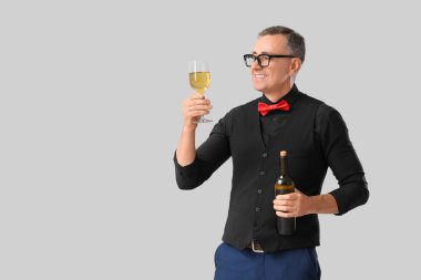 Hafif arka planda cam ve bir şişe şarapla olgunlaşmış şarap garsonu.