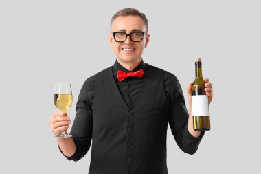 Hafif arka planda cam ve bir şişe şarapla olgunlaşmış şarap garsonu.