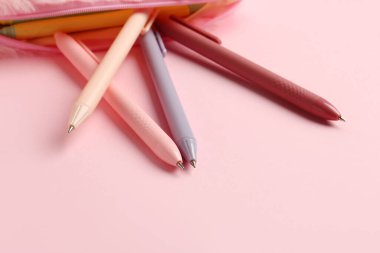 Pembe arka planda kalemleri olan bir kalem kutusu. Yakın çekim.