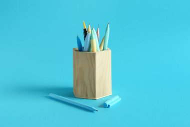 Mavi arka planda kalemleri olan ahşap tutucu