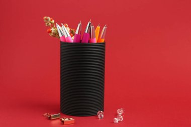 Kırmızı arkaplanda kalemleri olan tutucu