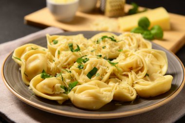 Siyah arka planda peynirli ve fesleğenli haşlanmış hamur köftesi tabağı.