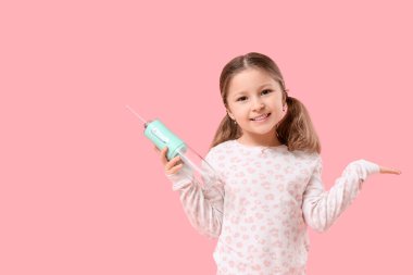 Pembe arka planda ağız sulandırıcısı olan tatlı küçük bir kız.