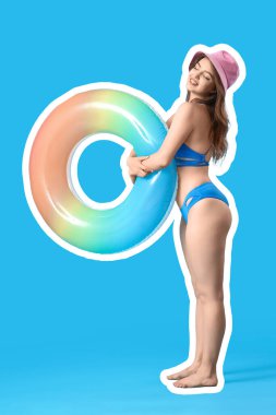 Açık mavi arka planda şişme yüzüğü olan genç bir kadın.