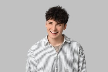 Hafif arka planda diş telleri olan gülümseyen genç adam.