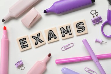 Kelime EXAMS ile kompozisyon ve beyaz arkaplan üzerinde farklı kırtasiye, yakın çekim