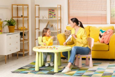 Ofisinde küçük şirin bir kızın mektup okuduğu kadın konuşma terapisti.