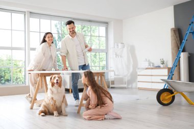 Yeni evlerinin tamiri sırasında köpekli mutlu bir aile.