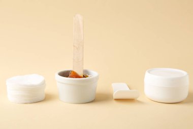 Pamuk pedler, bej arka planda şekerleme macunu ve krema. Epilasyon kavramı