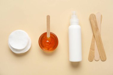 Şekerleme macunu, pamuk pedleri, krem ve spatulalar bej arka planda, üst manzara. Epilasyon kavramı