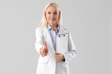 Elinde pano olan olgun bir iş kadını, arka planda sanal ekran kullanıyor