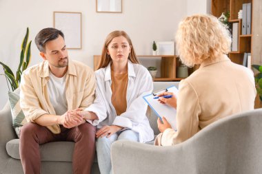 Ofise gelen genç çift için üzgün psikolog.