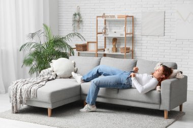 Dar kotlu şişman kadın evdeki kanepede uzanıyor. Aşırı ağırlık kavramı