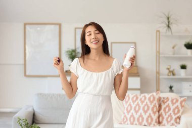 Evinde lezzetli yoğurt şişesiyle güzel bir Asyalı kadın.