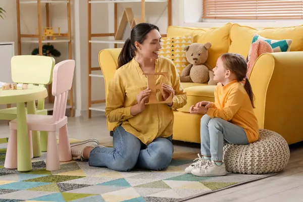 stock image Female speech therapist with cute little girl pronouncing letter E in office