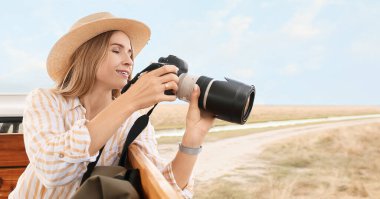 Safaride fotoğraf makinesi olan güzel bir bayan turist.