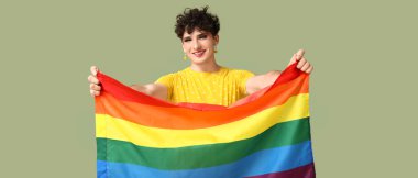 Yeşil arka planda LGBT bayrağı olan genç transseksüel kadın.