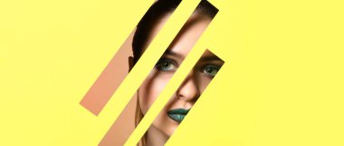 Parlak makyajlı güzel bir kadın. Kesik sarı kağıttan görülebiliyor.