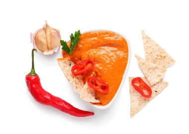 Bir kase lezzetli muhammara ve beyaz arka planda malzemeler.