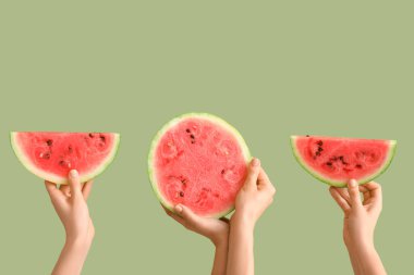 Yarı yarıya kadın eli ve yeşil arka planda olgun karpuz dilimleri.