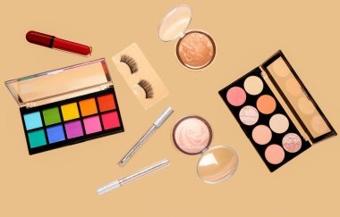 Uçan dekoratif kozmetik soluk turuncu arka planda