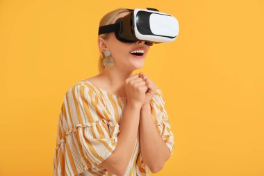 Turuncu arka planda modern VR gözlüklü mutlu genç kadın.