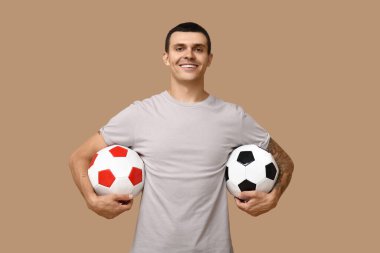 Kahverengi arka planda futbol topları olan yakışıklı bir genç.