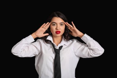 Siyah arka planda şık aksesuarları olan güzel genç bir kadın.