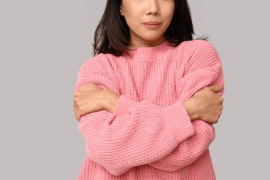 Genç kadın arka planda kendine sarılıyor, yakın plan.