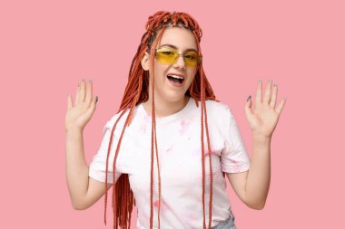 Pembe arka planda rastalı genç kadın portresi