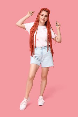 Pembe arka planda rastalı güzel bir genç kadının portresi.