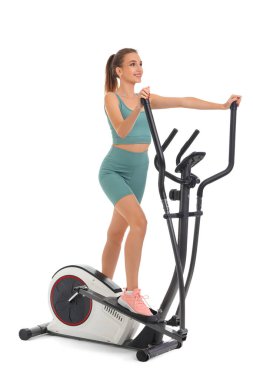 Beyaz arka planda bisiklet egzersizi yapan genç bir bayan.