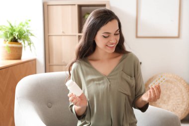 Genç bir kadın evde hap seçiyor.