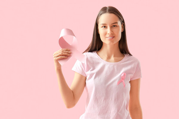 Красивая женщина с розовыми лентами на цветном фоне. Концепция информированности о раке груди