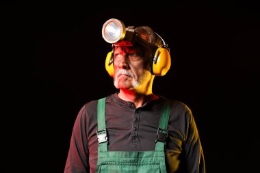 Mature miner man with headlamp on black background clipart