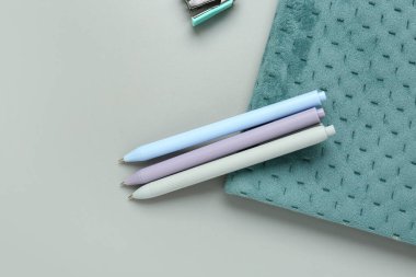 Gri arkaplanda kalemleri olan defter