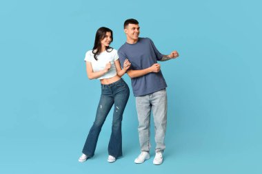 Mavi arka planda dans eden mutlu genç çift