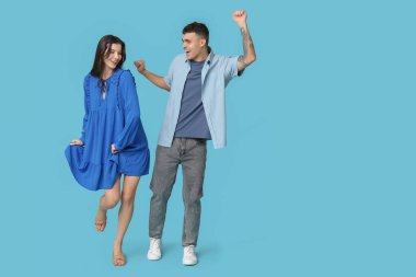 Mavi arka planda dans eden mutlu genç çift