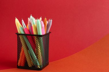 Renkli arkaplanda farklı kalemlere sahip tutucu