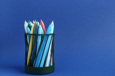 Mavi arkaplanda farklı kalemler bulunan şık tutucu