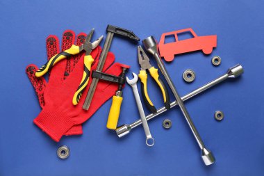 Mavi arka planda bir takım mekanik aletler ve kağıt araba. Mekanik kavram